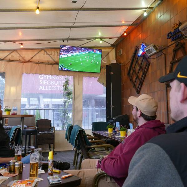 Menschen schauen Fußball in einer Kneipe.