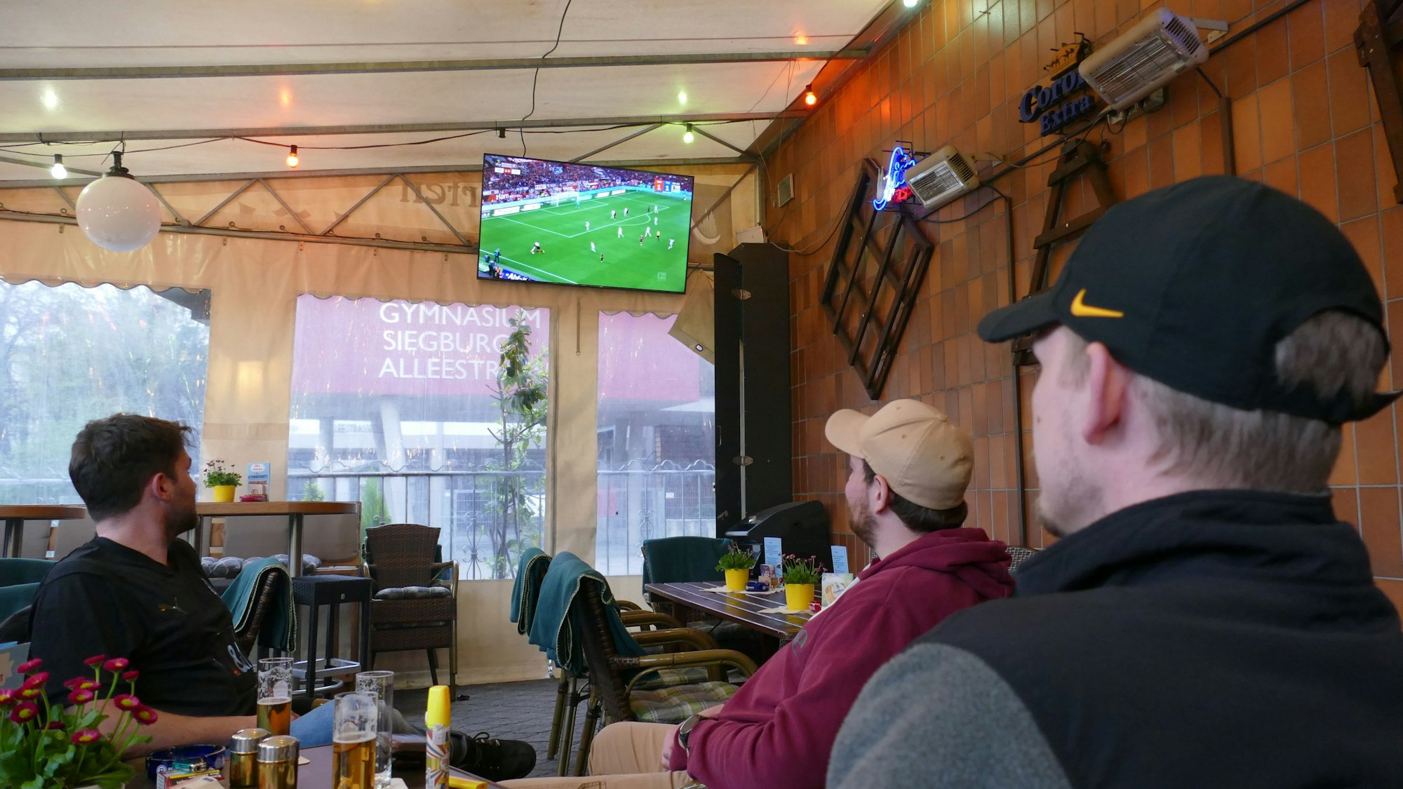 Menschen schauen Fußball in einer Kneipe.