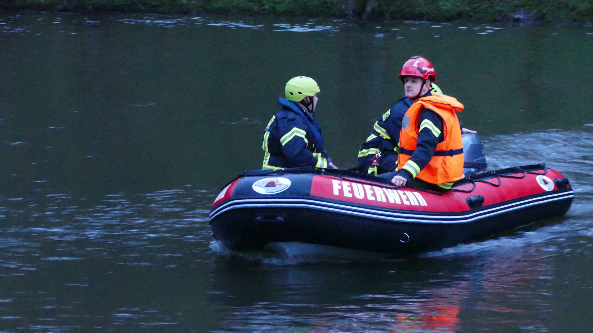 Feuerwehrleute sitzen in einem Boot.