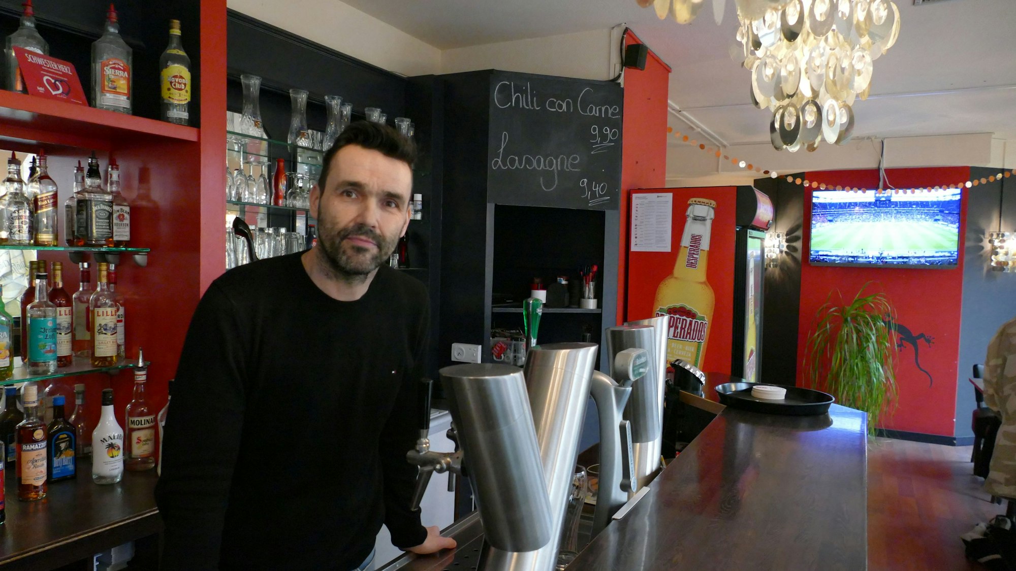 Ein Kneipenwirt steht hinter der Theke.