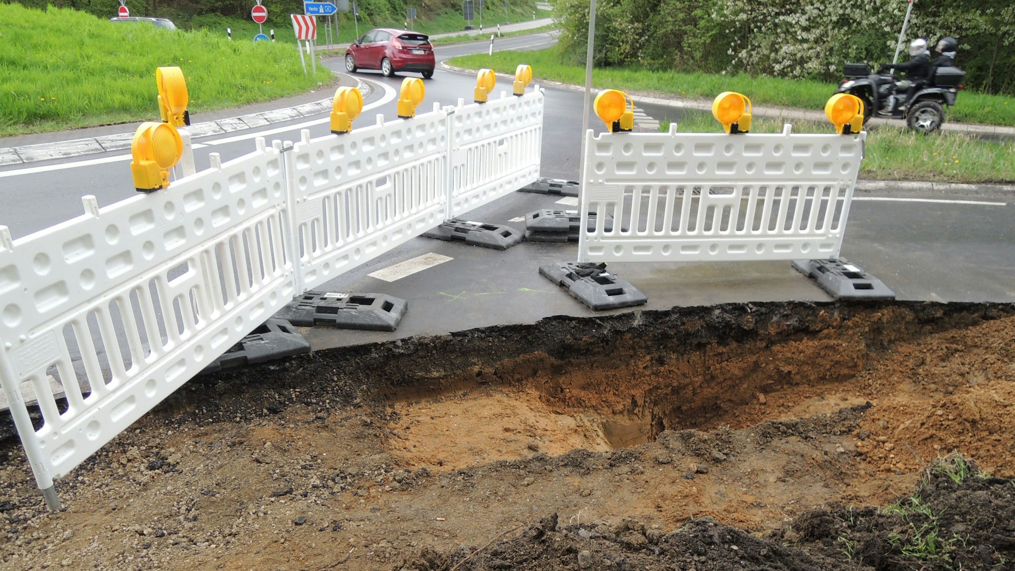 Am Rande des Kreisels klafft ein tiefes Loch im Boden. Die Landstraße an der Bedburger Anschlussstelle zur Autobahn 61 ist einseitig gesperrt.