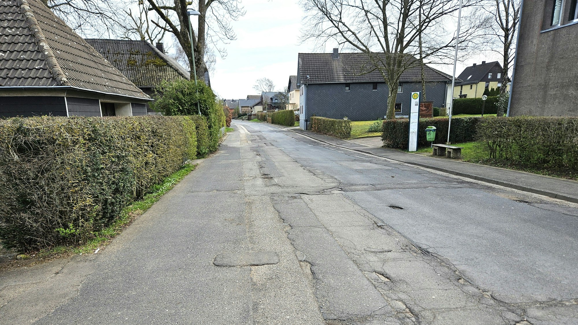 Blick auf die Ortsdurchfahrt mit der mehrfach geflickten Straße.