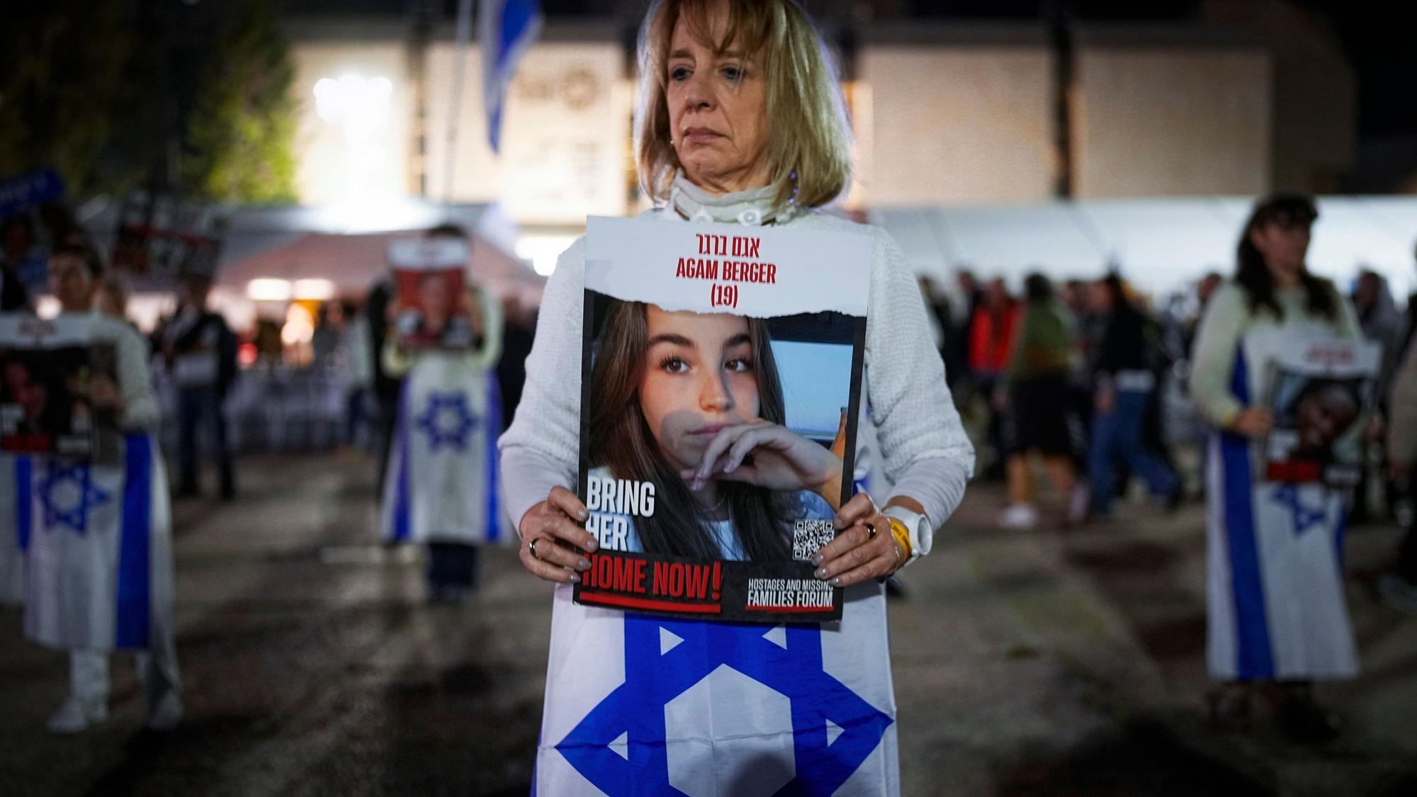 Frau, die eine Israel-Fahne und ein Bild mit einem Mädchen in die Kamera hält