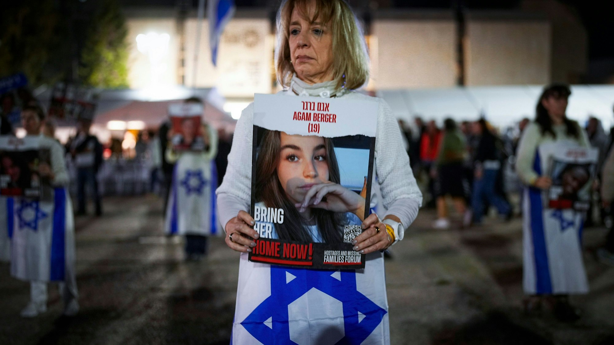 Frau, die eine Israel-Fahne und ein Bild mit einem Mädchen in die Kamera hält