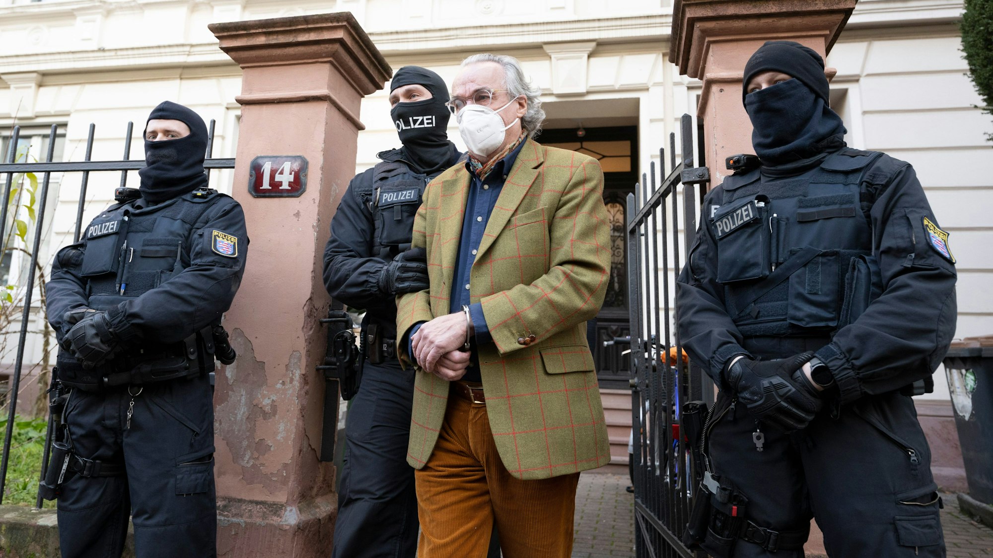 Bei einer Razzia gegen „Reichsbürger“ führen vermummte Polizisten nach der Durchsuchung eines Hauses Heinrich XIII. Prinz Reuß (2.v.r.) zu einem Polizeifahrzeug. (Archivbild)