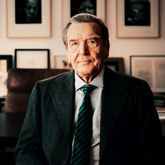 Das Bild zeigt den Altkanzler in seiner Kanzlei. Er trägt einen Anzug mit Krawatte. Im Hintergrund das Büro und zahlreiche Bilderrahmen an den Wänden.