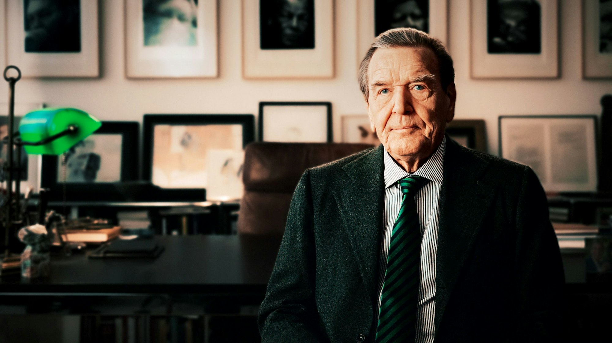 Das Bild zeigt den Altkanzler in seiner Kanzlei. Er trägt einen Anzug mit Krawatte. Im Hintergrund das Büro und zahlreiche Bilderrahmen an den Wänden.