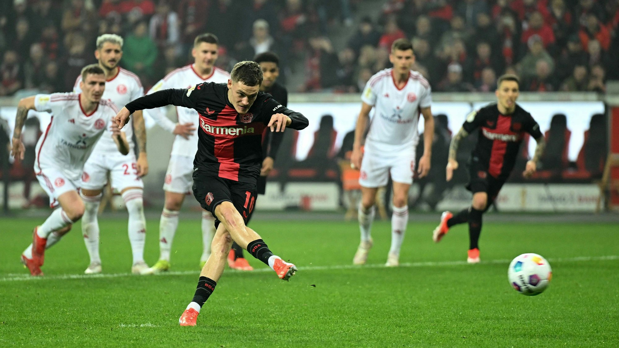 Bayer Leverkusen's German midfielder #10 Florian Wirtz shoots and scores the team's fourth goal during the German Cup (DFB-Pokal) semi-final football match between Bayer 04 Leverkusen and Fortuna Duesseldorf in Leverkusen, western Germany on April 3, 2024. (Photo by INA FASSBENDER / AFP) / DFB REGULATIONS PROHIBIT ANY USE OF PHOTOGRAPHS AS IMAGE SEQUENCES AND QUASI-VIDEO.