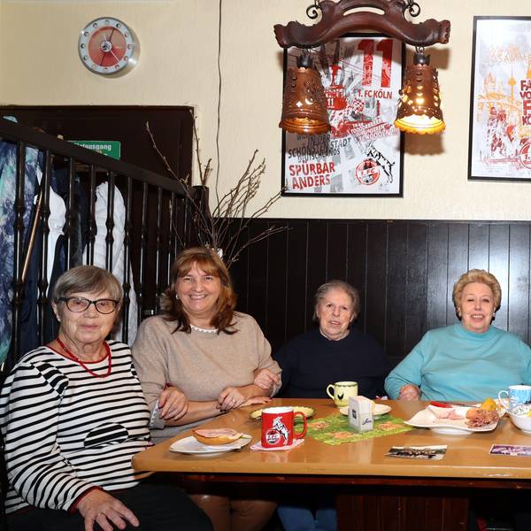 Sechs Seniorinnen, die an einem Tisch mit Frühstücksgedeck in einer Kölner Kneipe sitzen