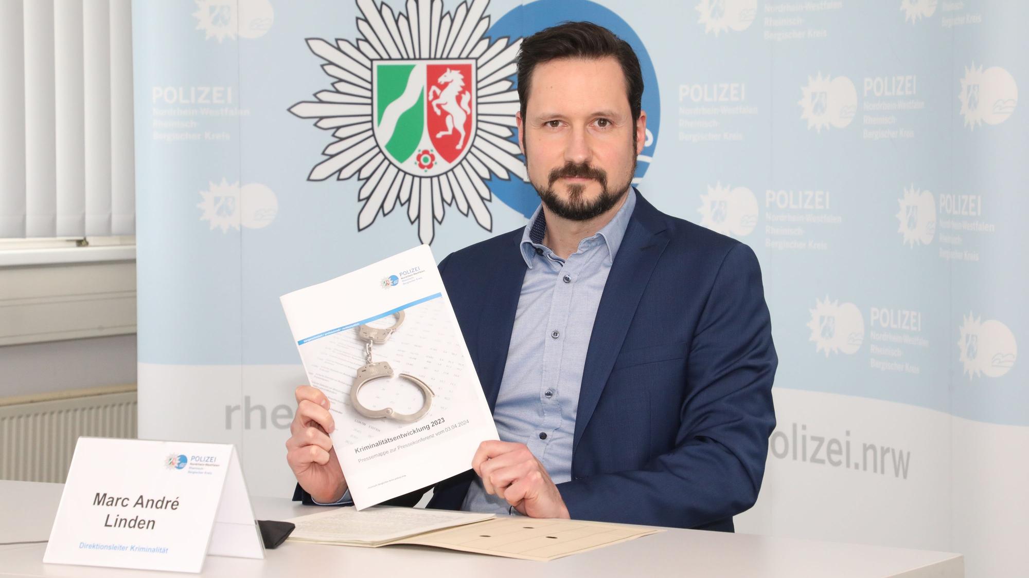 Rhein-Bergs Kripo-Chef Marc André Linden hält die Kriminalitätsstatistik 2023 für Rhein-Berg in den Händen.