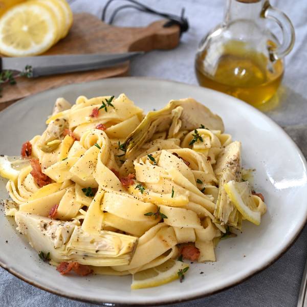 Neben der cremigen Artischockensoße machen auch gegrillte Artischockenherzen, knuspriger Bauchspeck und süßliche Zitrusnoten aus einfachen Bandnudeln einen herzhaften Pastaschmaus.