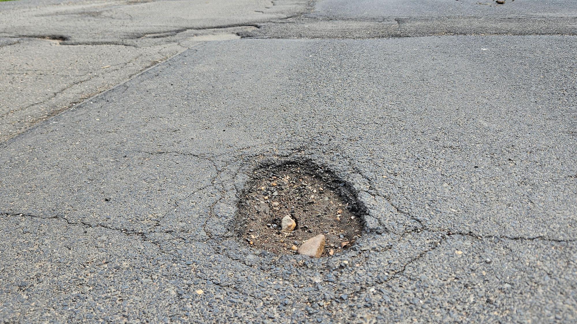 Das Foto zeigt ein Loch im Asphalt in der Ortsdurchfahrt von Herhahn.