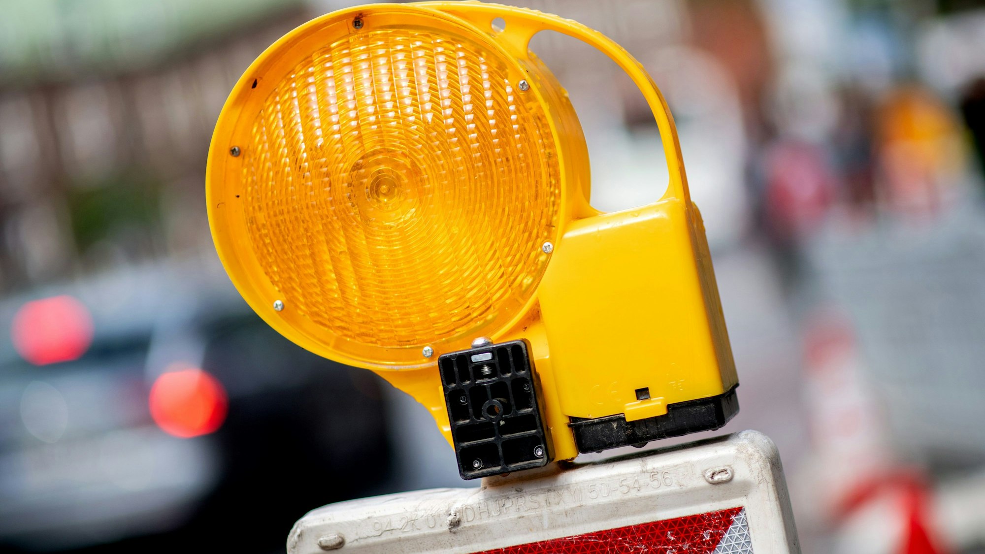 Eine Leitbake mit einer Warnleuchte steht an einer Baustelle in der Innenstadt.