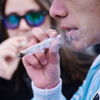 Zwei Menschen rauchen einen Joint bei einer Demonstration in Berlin.