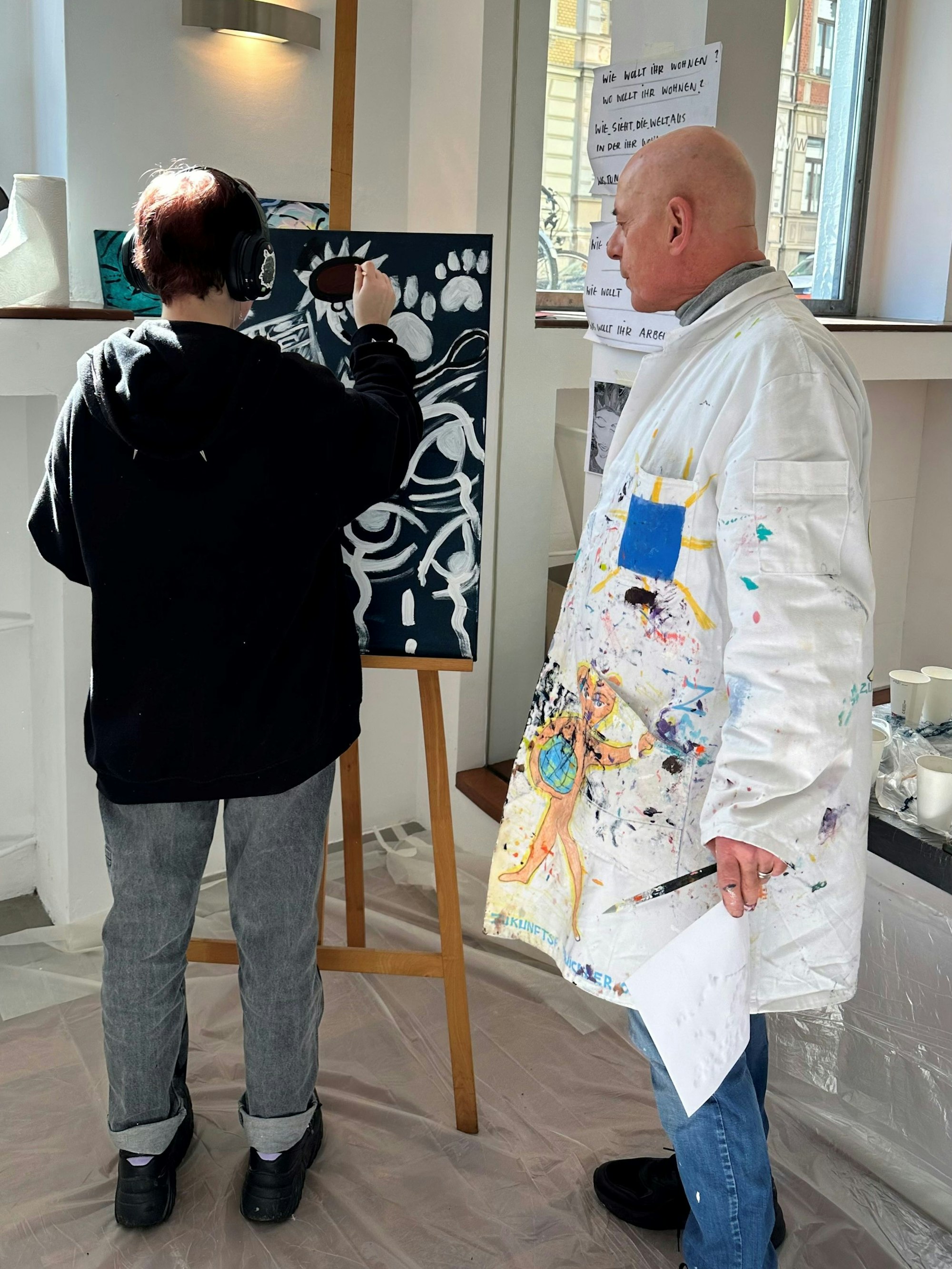 Kiddy Citny malt gemeinsam mit Kindern.