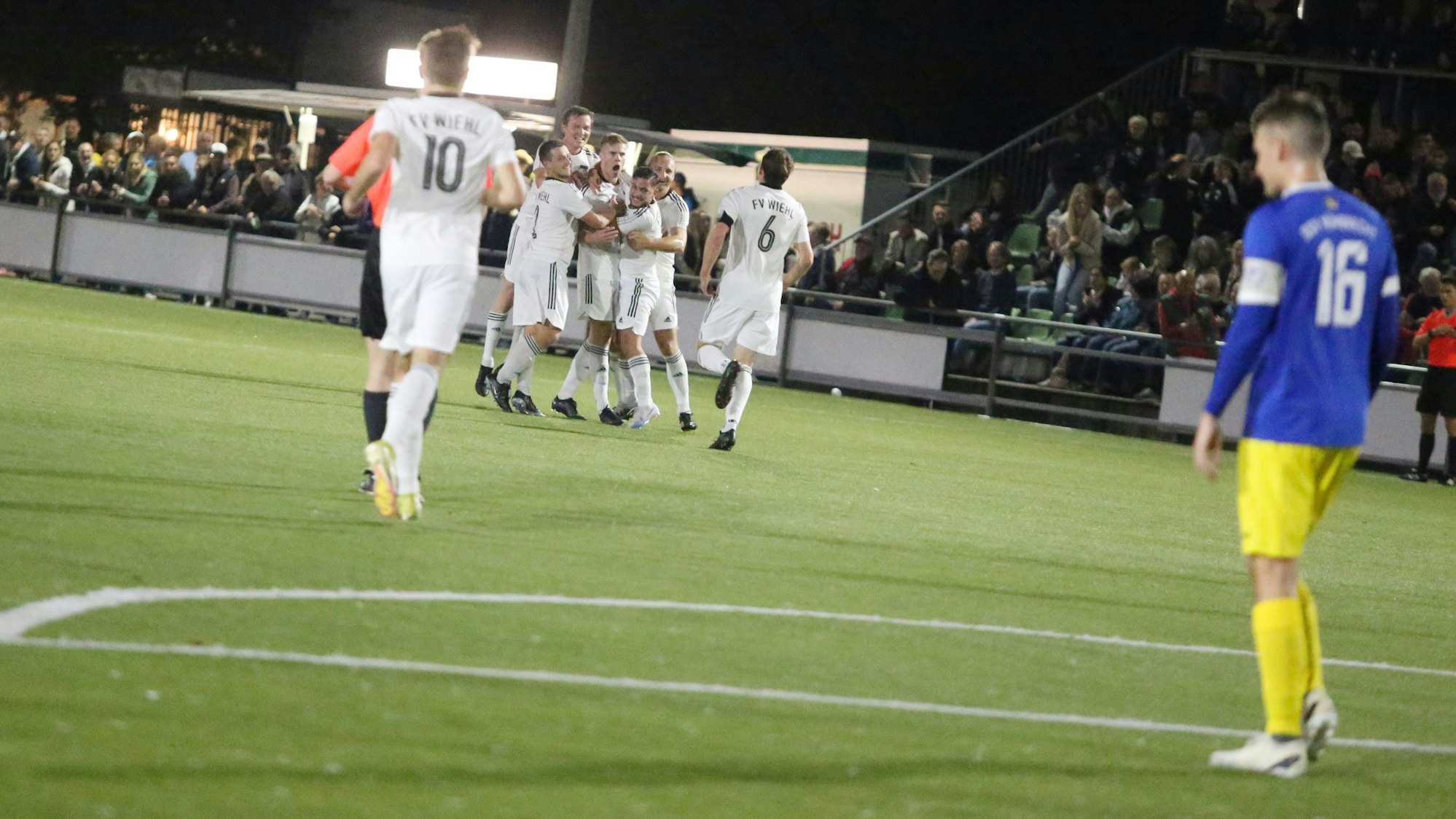 Am Rand steht ein Fußballer des SSV Nümbrecht, der beobachtet wie die Wiehler Fußballer jubeln.