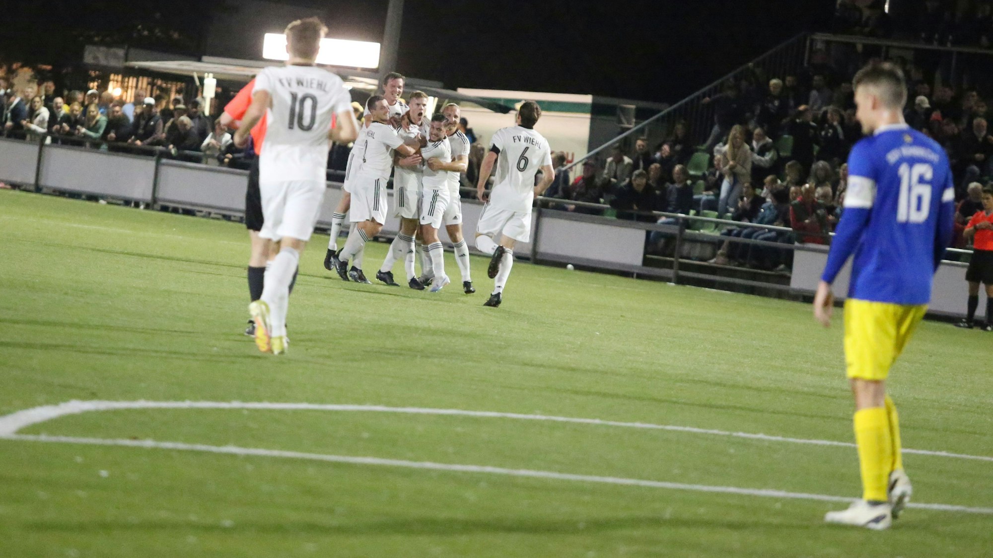 Am Rand steht ein Fußballer des SSV Nümbrecht, der beobachtet wie die Wiehler Fußballer jubeln.