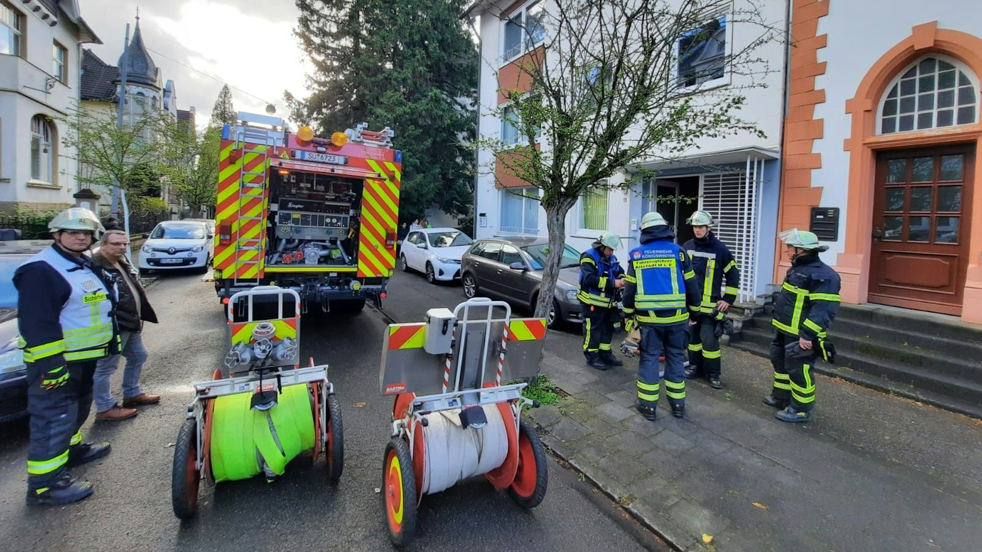 Einsatzkräfte der Feuerwehr halten Schläuche bereit für einen Löschangriff.