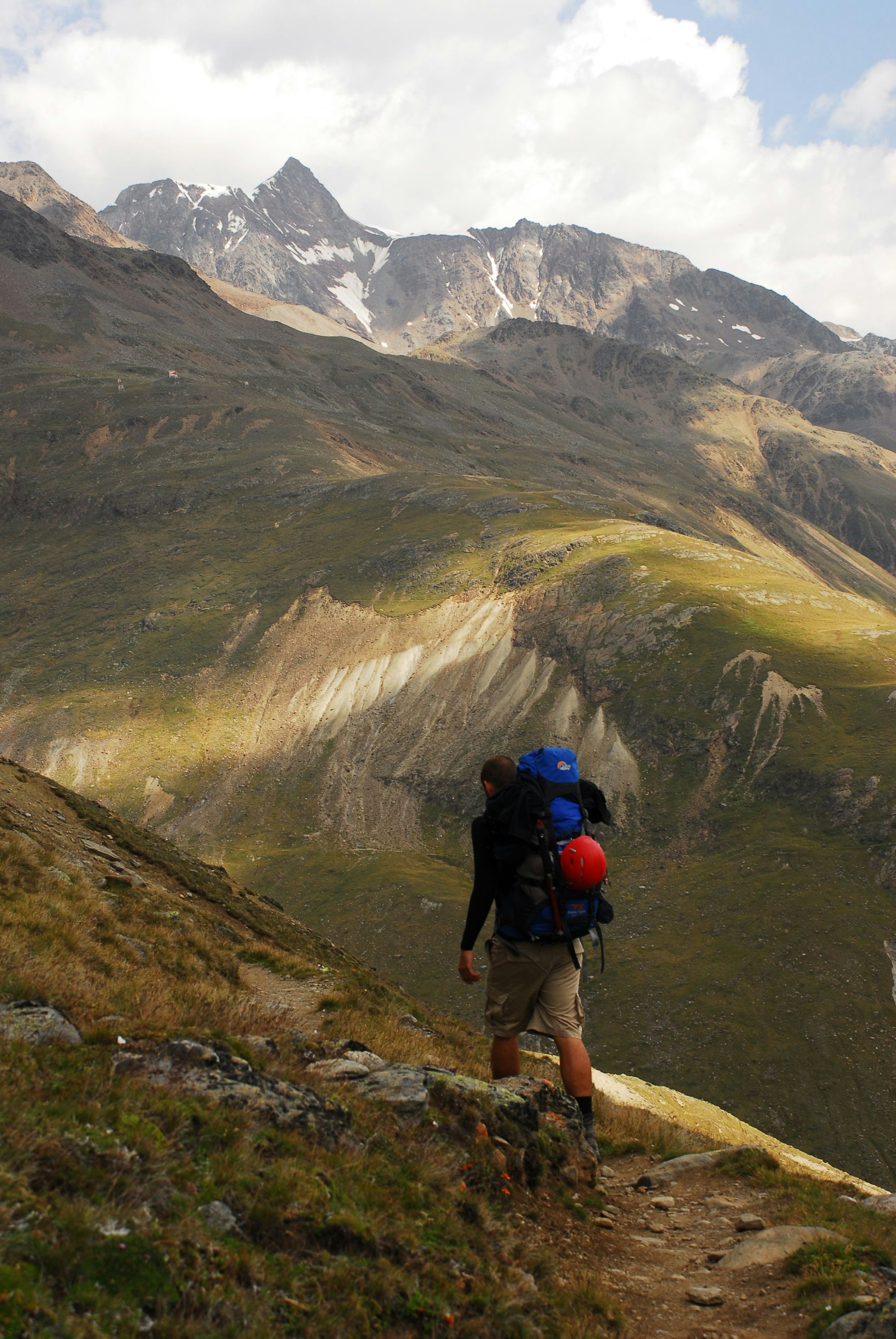 Ein Wanderer ist in einem Gebirge unterwegs.