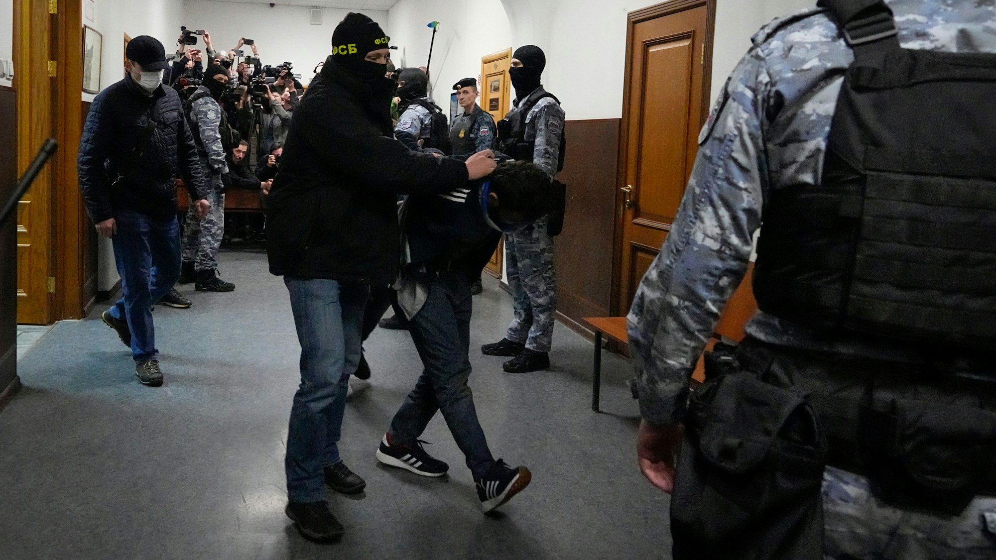 Russische Polizisten führen einen Verdächtigen des Terroranschlags in ein Gericht. (Archivbild)