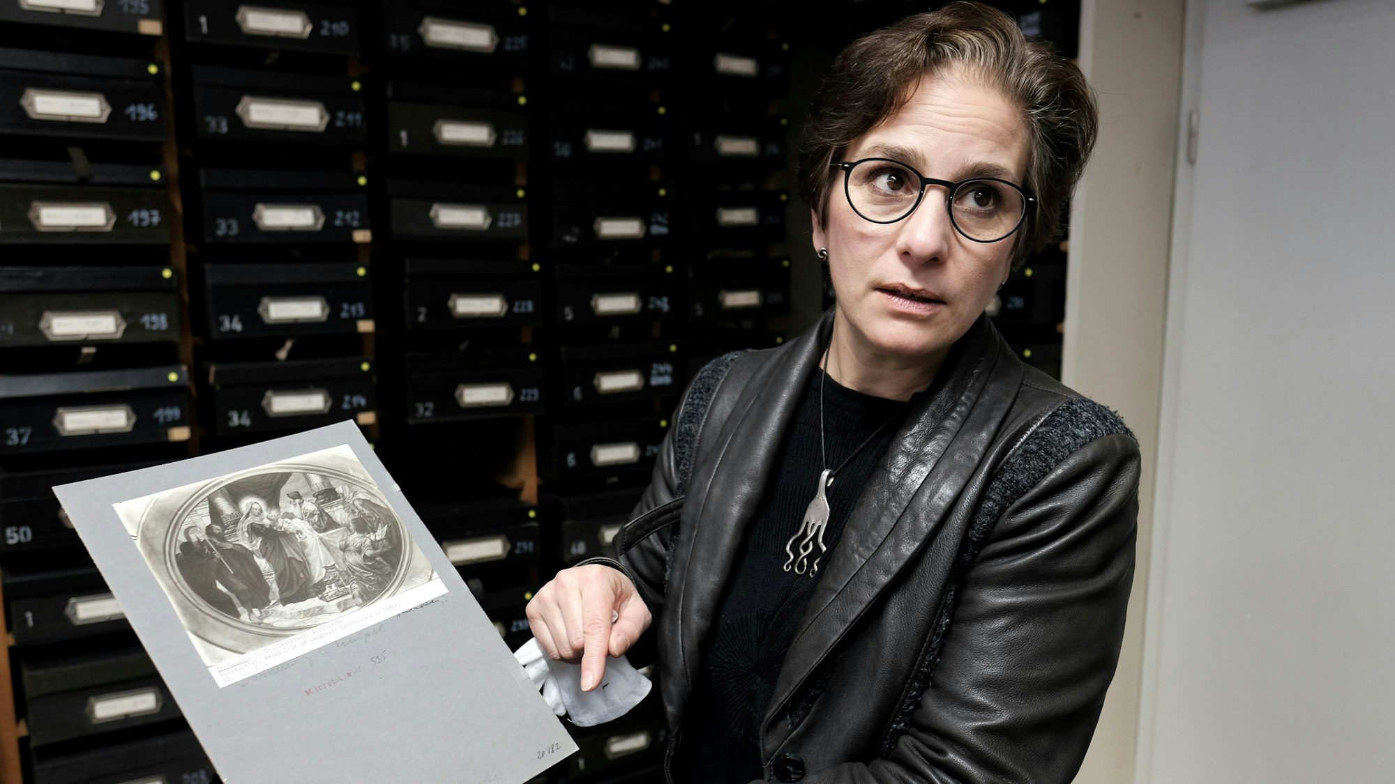 Johanna Gummlich zeigt ein Fotodokument aus dem Rheinischen Bildarchiv