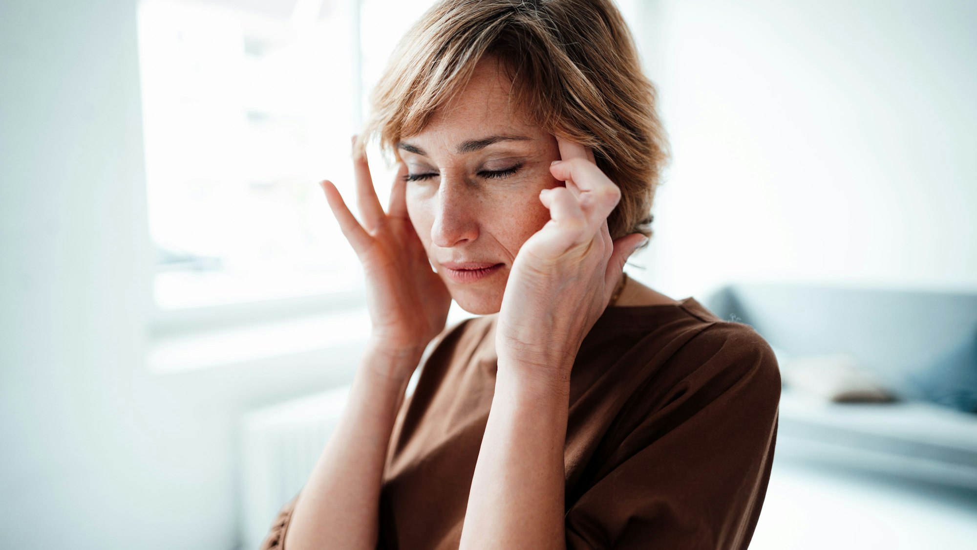 Eine Frau hält sich ihren Kopf