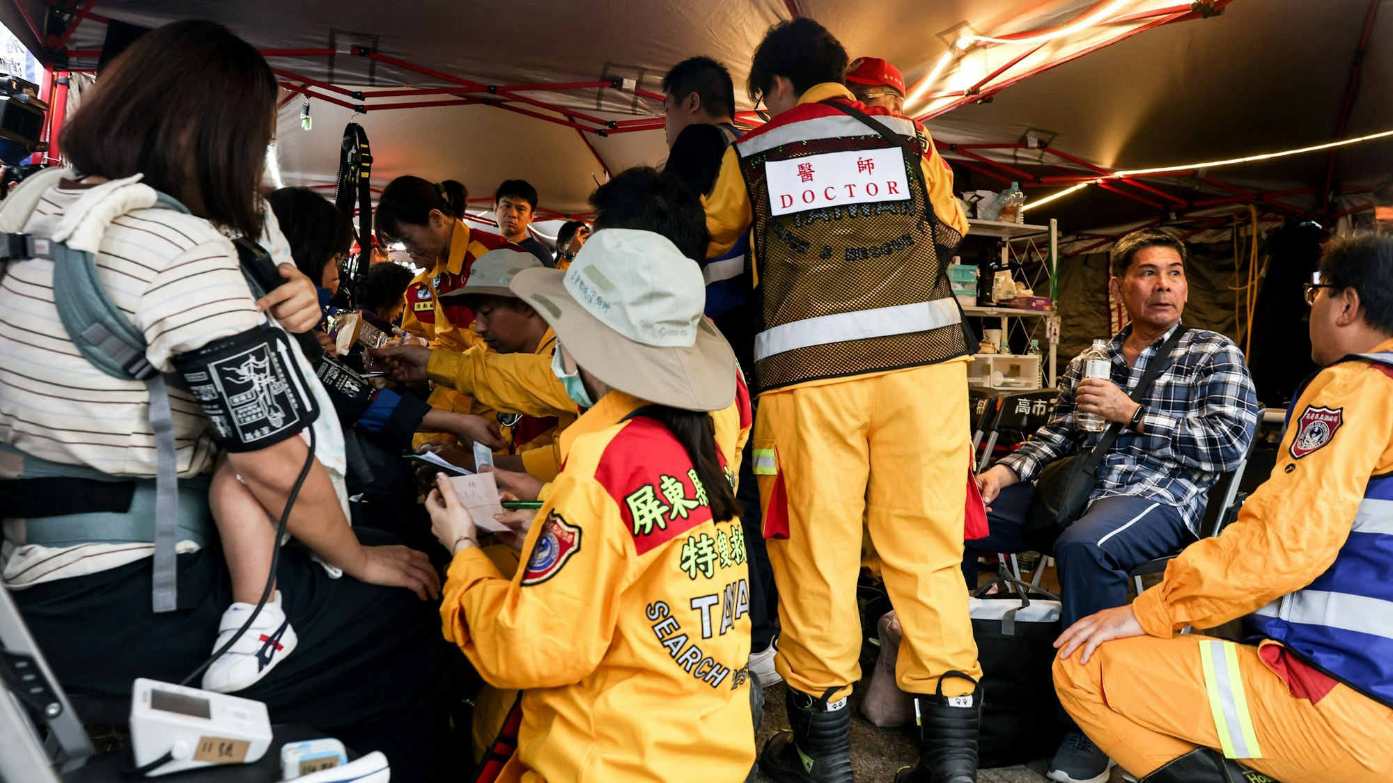 Menschen werden an einem provisorischen Rettungskommandoposten medizinisch versorgt.