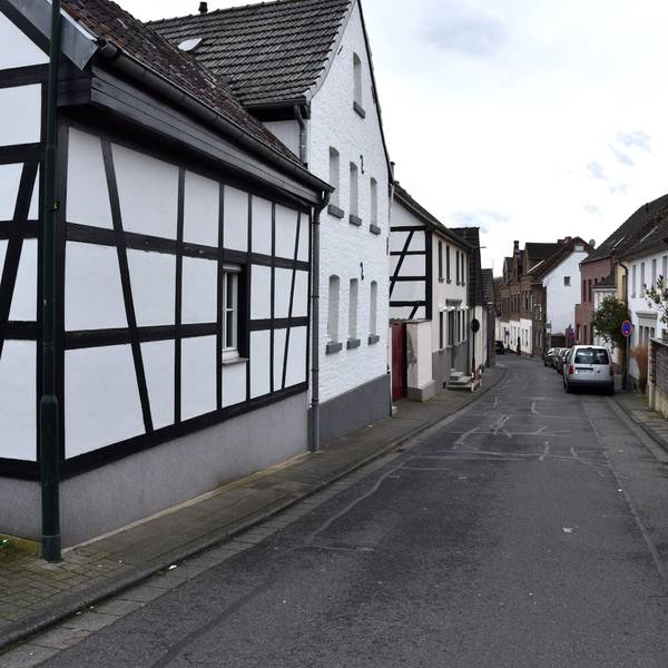 Zu sehen ist eine Straße mit Fachwerkhäusern.