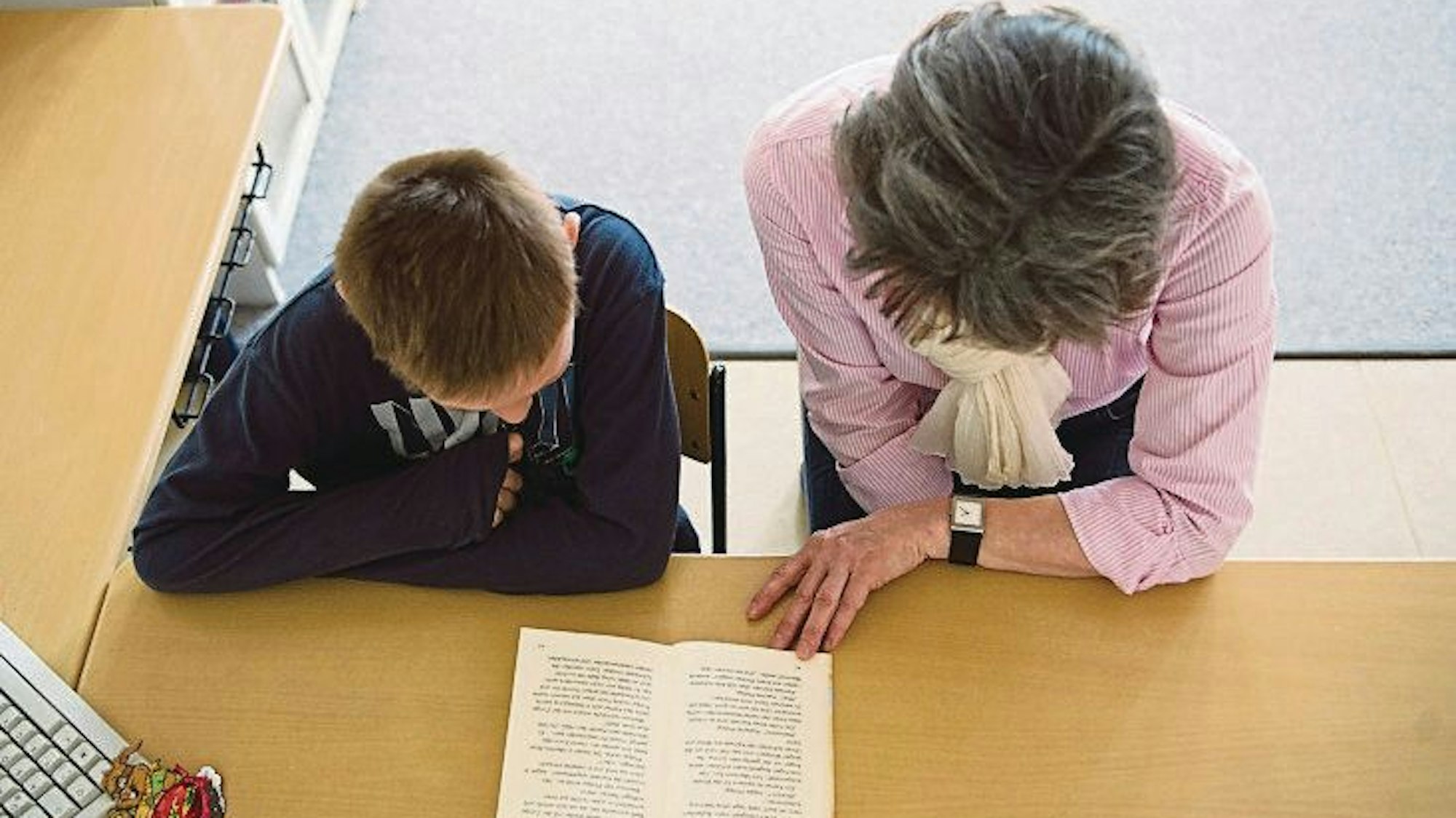 Die Mentorin Anja Osen und der Schüler Dustin Grabowski lesen in der Grundschule ein Buch.