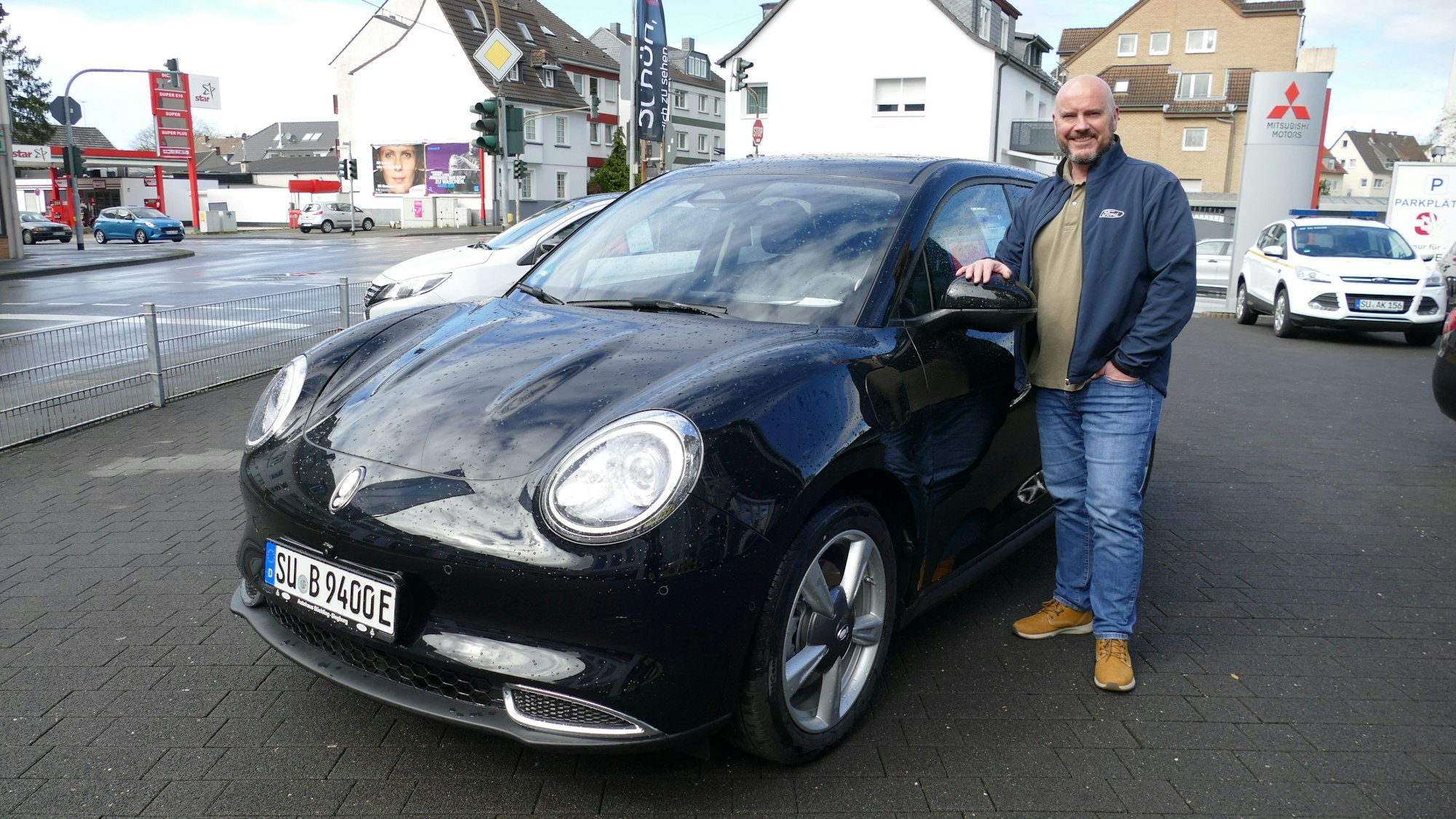 Verkaufsleiter Michael Bellinghausen vom Siegburger Autohaus Büchling steht neben einem Elektroauto des chinesischen Herstellers Ora.