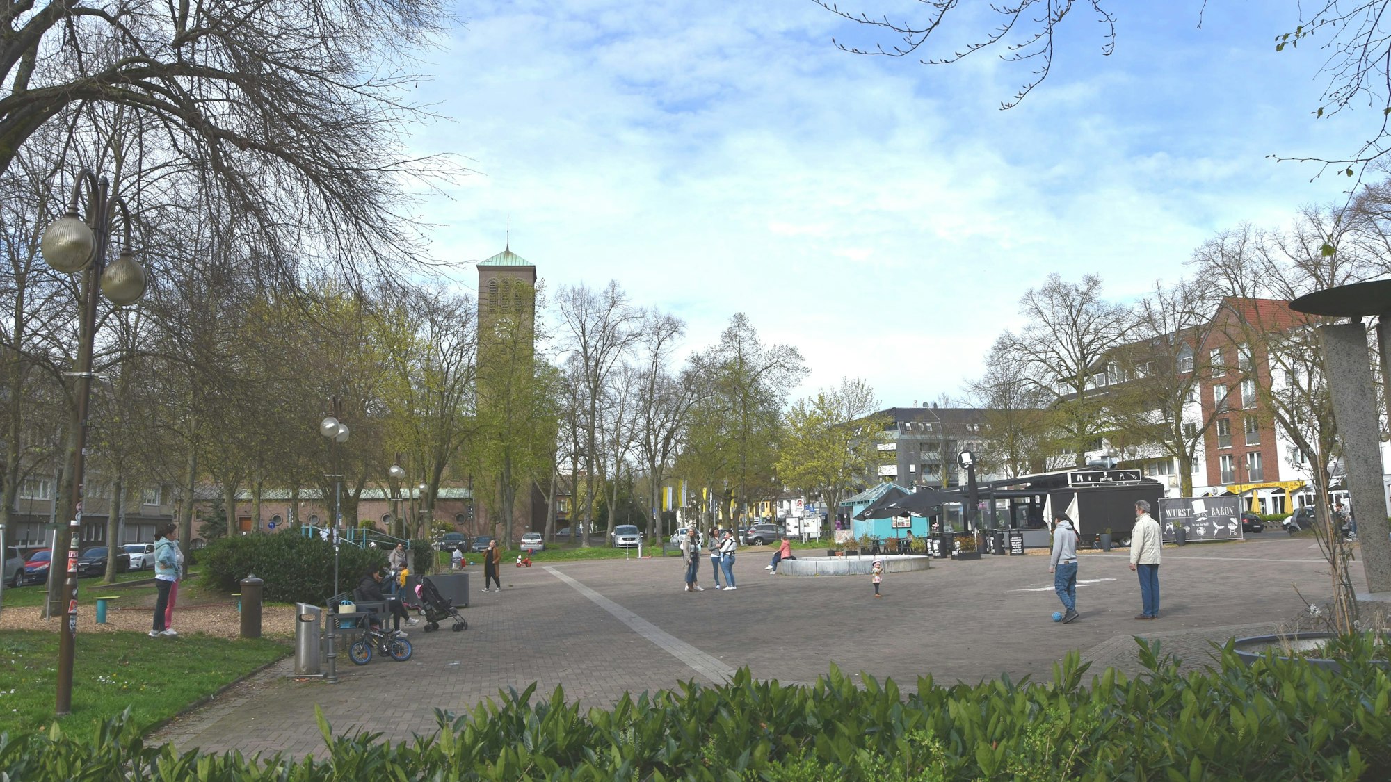Zu sehen ist ein Platz, auf dem sich Menschen aufhalten.