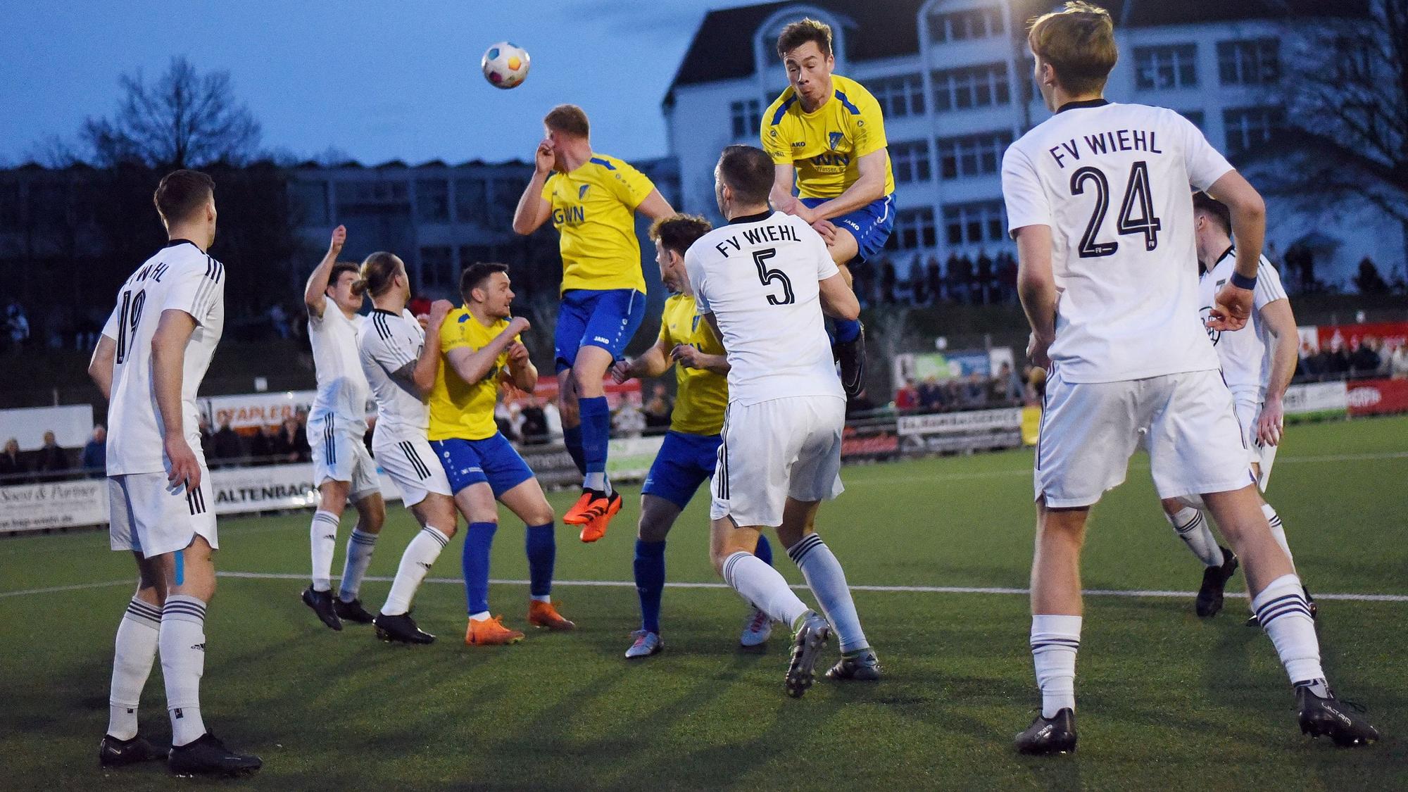 Zwei Nümbrechter springen in der Abwehr der Wiehler zum Kopfball hoch.