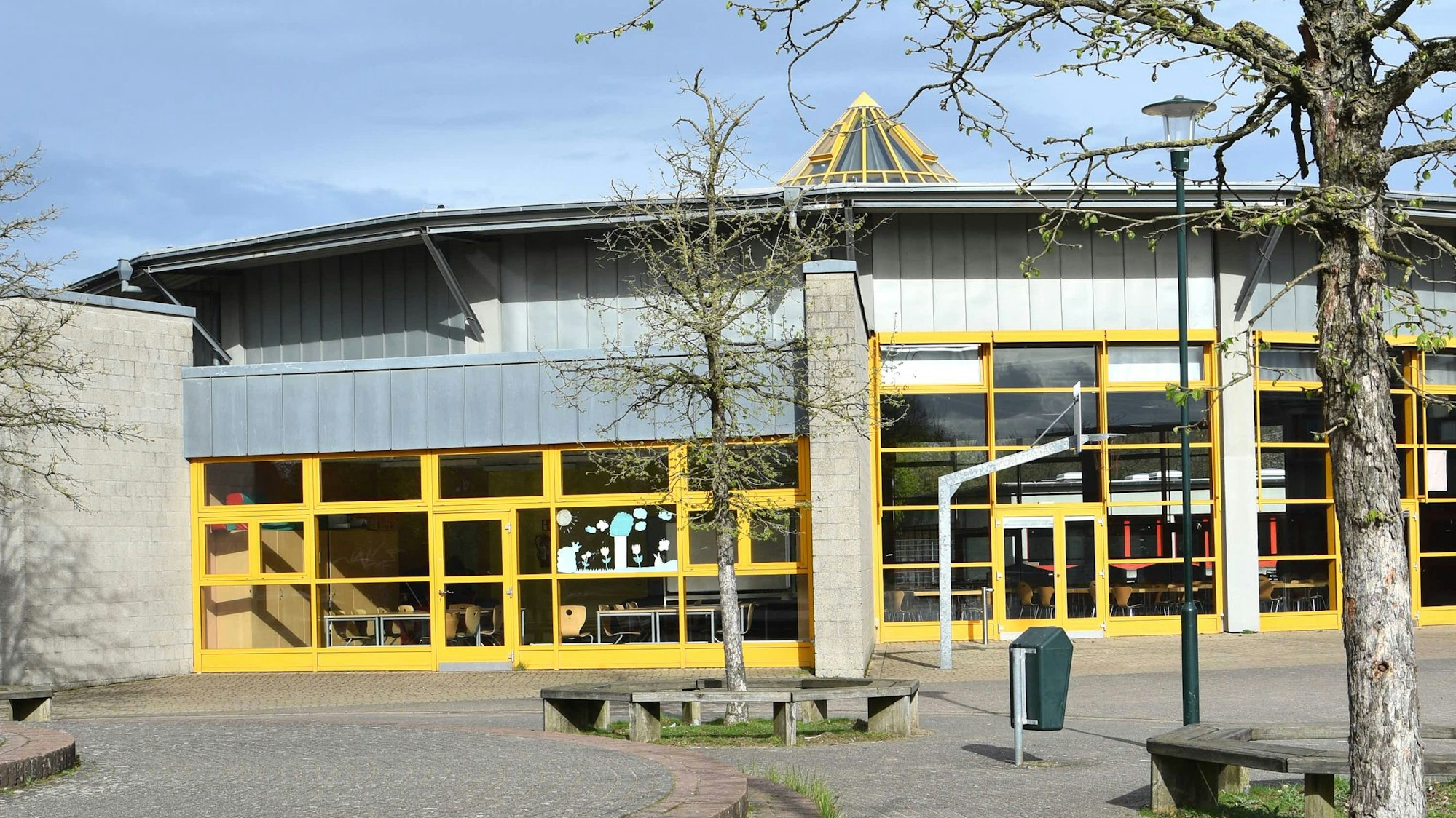 Zu sehen ist eine Schule mit gelber Front.