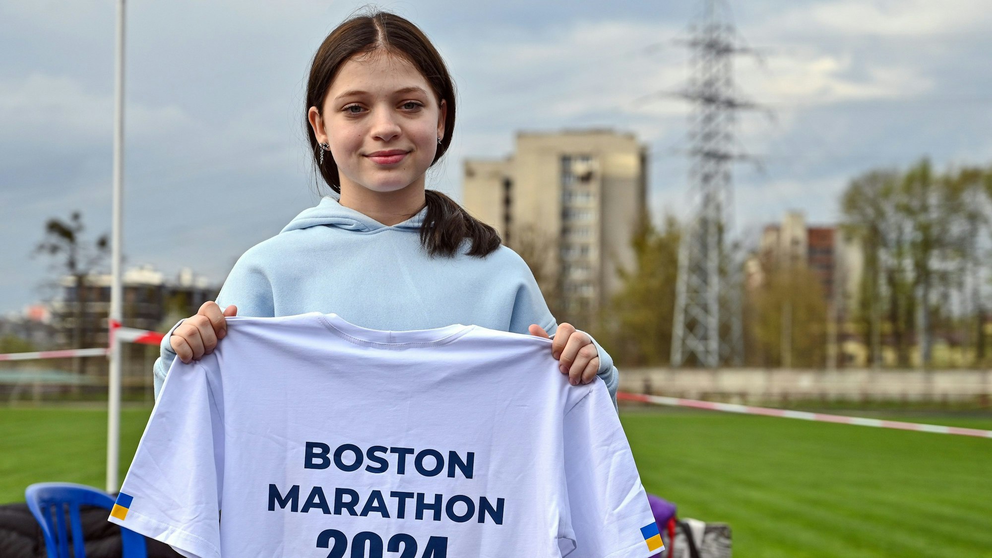 Ukraine, Lwiw: Die 12-jährige Ukrainerin Jana Stepanenko zeigt ein T-Shirt mit der Aufschrift „Boston Marathon 2024“.