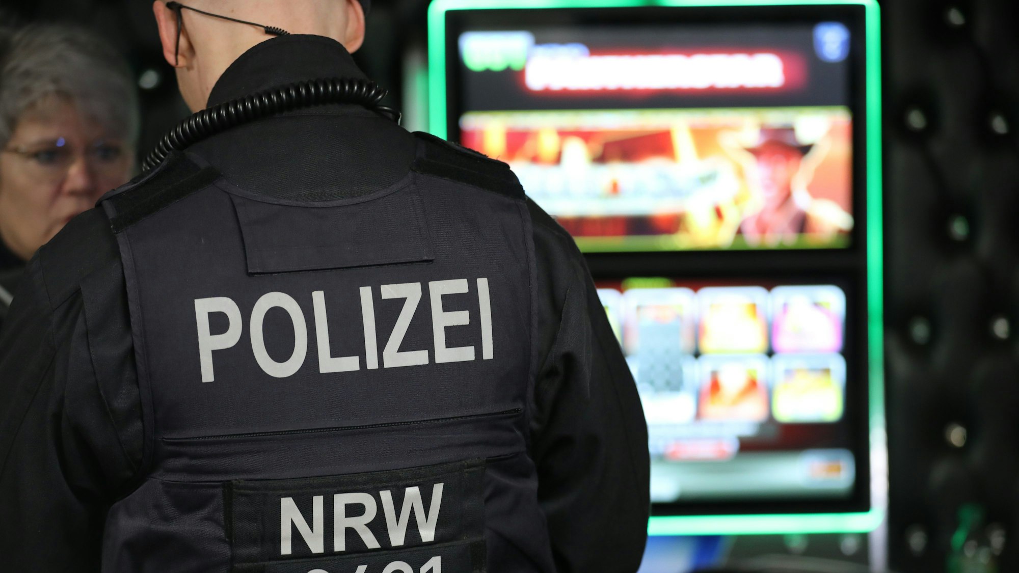 Nordrhein-Westfalen, Duisburg: Ein Polizist steht an einem Glücksspielgerät bei der Durchsuchung einer Glücksspielhalle.