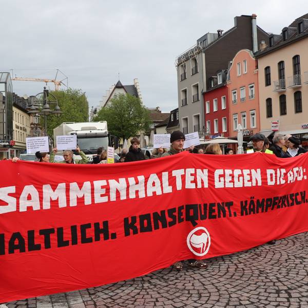 Zu sehen sind die Demonstranten, die ein Banner halten.