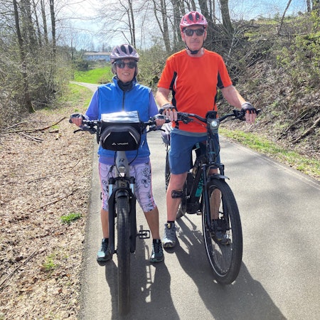 Ein Ehepaar steht mit seinen Fahrrädern auf einer Bahntrasse.