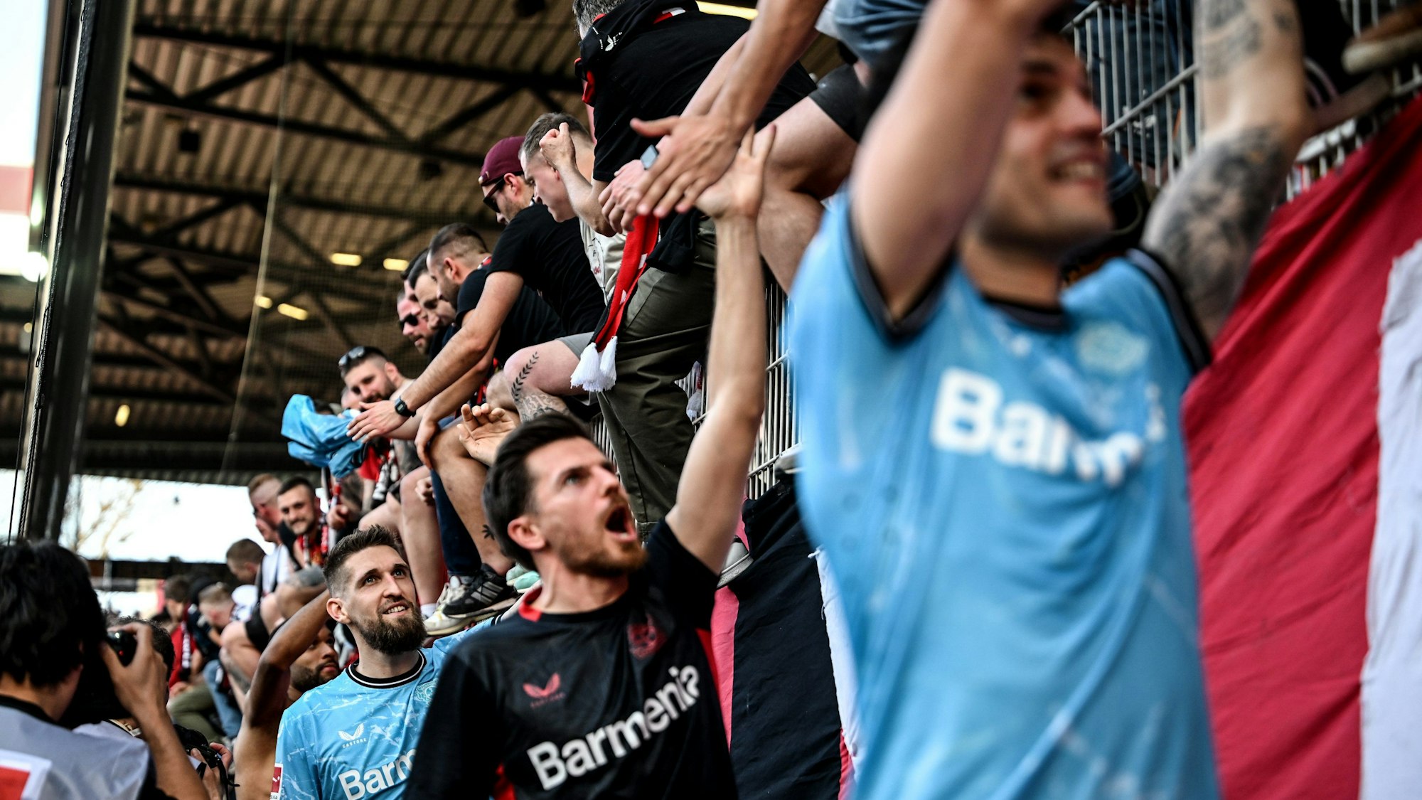 06.04.2024, Berlin: Fußball: Bundesliga, 1. FC Union Berlin - Bayer Leverkusen, 28. Spieltag, An der Alten Försterei. Leverkusens Robert Andrich (l) bedankt sich zusammen mit seinen Mitspielern nach dem Spiel bei den Fans. Foto: Britta Pedersen/dpa - WICHTIGER HINWEIS: Gemäß den Vorgaben der DFL Deutsche Fußball Liga bzw. des DFB Deutscher Fußball-Bund ist es untersagt, in dem Stadion und/oder vom Spiel angefertigte Fotoaufnahmen in Form von Sequenzbildern und/oder videoähnlichen Fotostrecken zu verwerten bzw. verwerten zu lassen. +++ dpa-Bildfunk +++