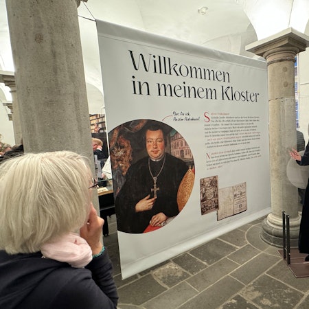 Zu sehen ist eine große Schautafel neben der eine Pappfigur Jürgen Rüttgers in Mönchsgewand zeigt.