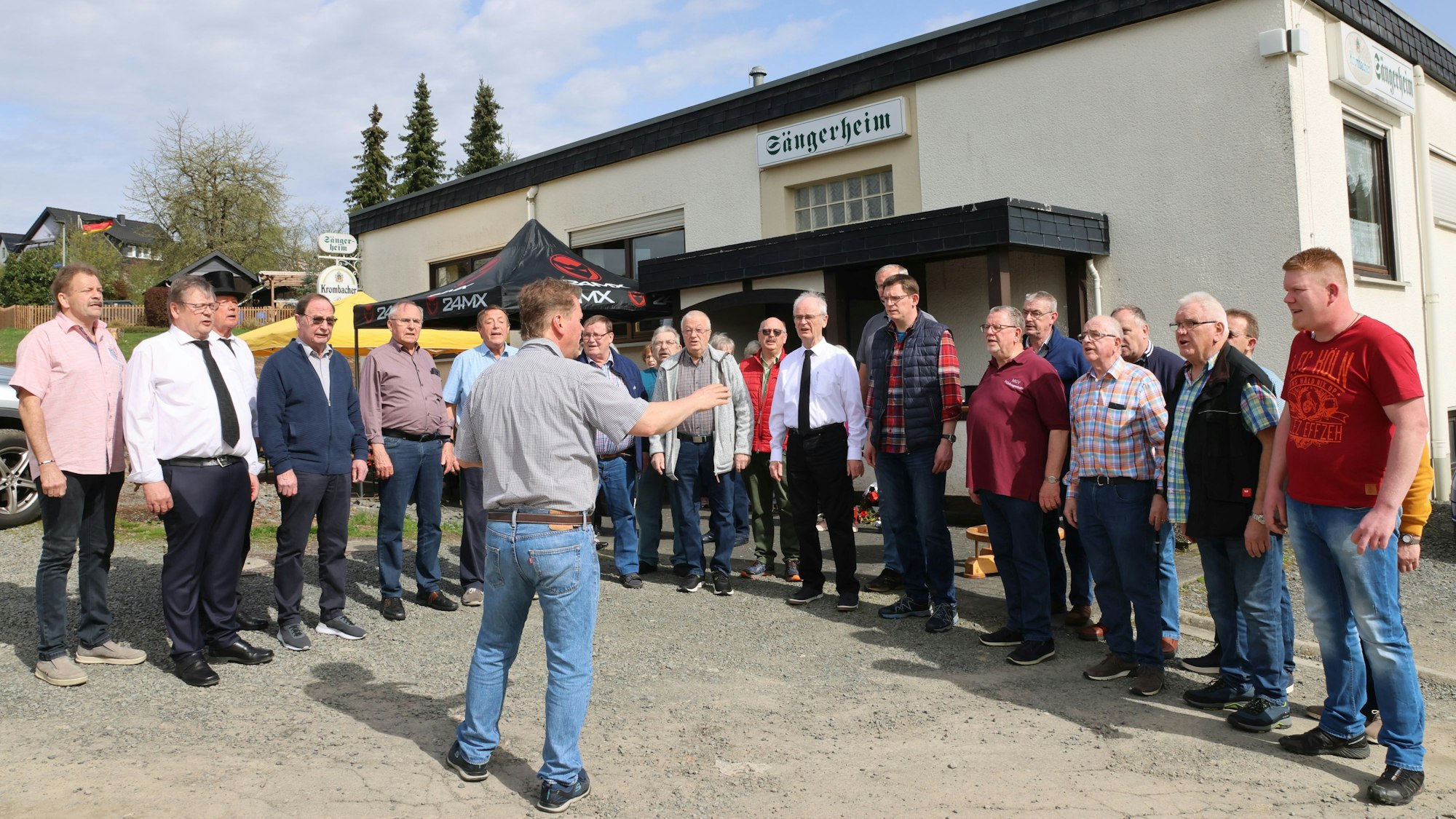 Ein Männerchor vor dem schlichten Zweckbau des Sängerheims.