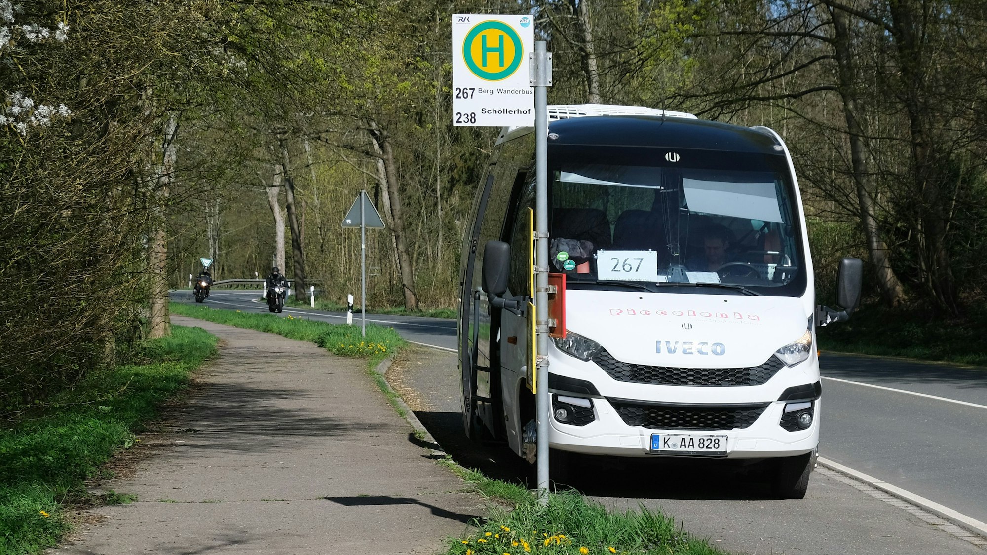 Der Bergische Wanderbus steht an einer Haltestelle.