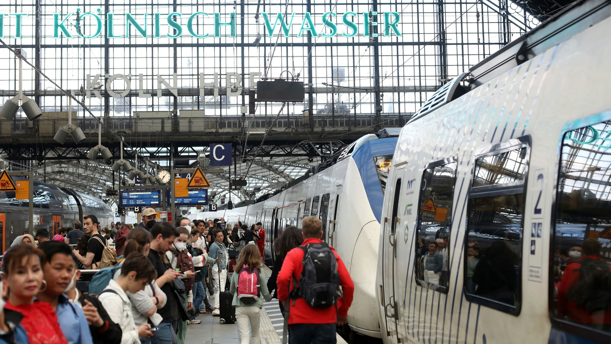 Fahrgäste warten auf ihre Zugverbindung auf Gleis 4 am Kölner Hauptbahnhof. Die Gleise sind voll, die Reisenden drängen sich an den Zugtüren. (Symbolbild)