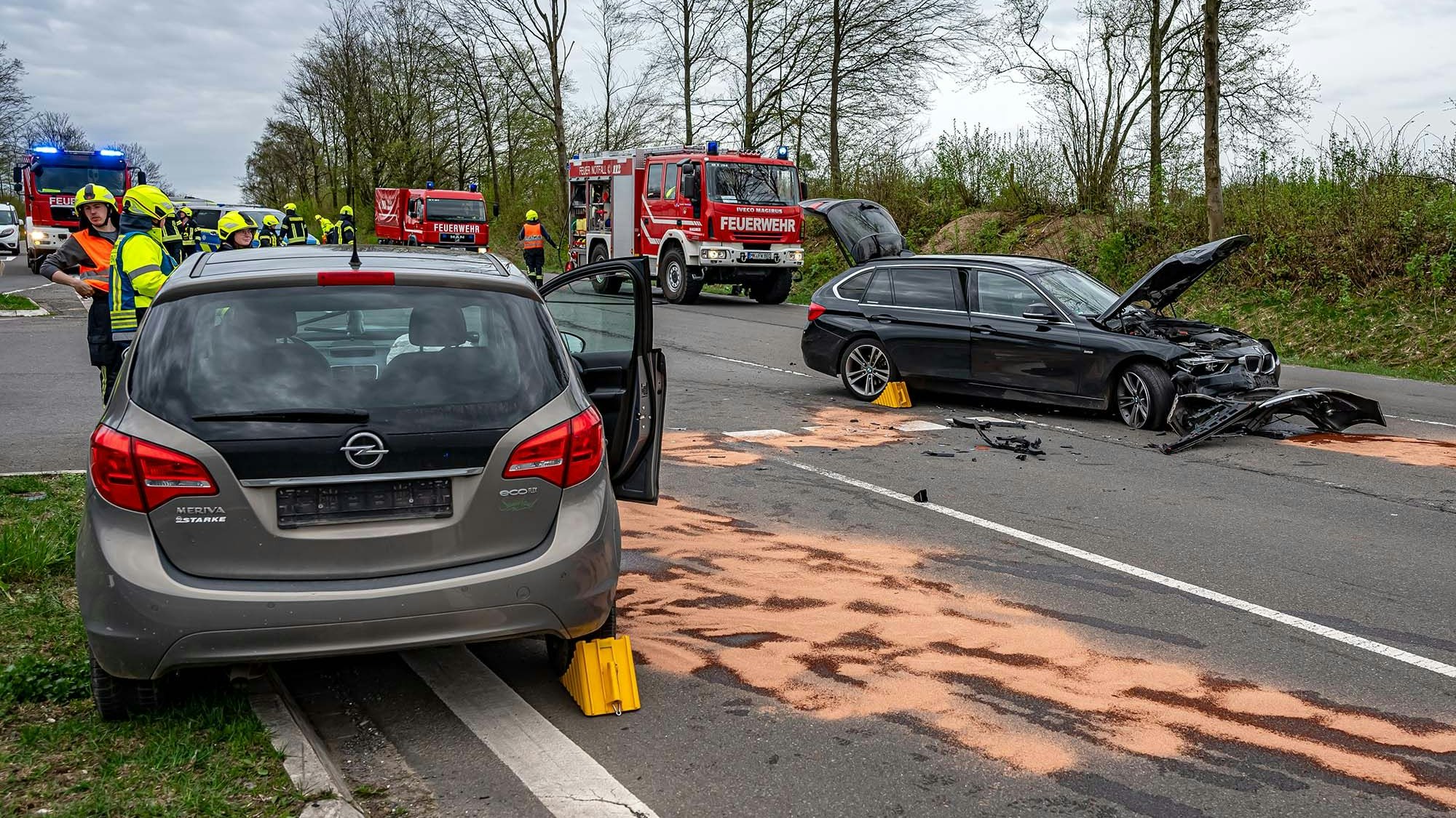 Zwei Unfallfahrzeuge und abgestreute Betriebsstoffe auf einer Straße.