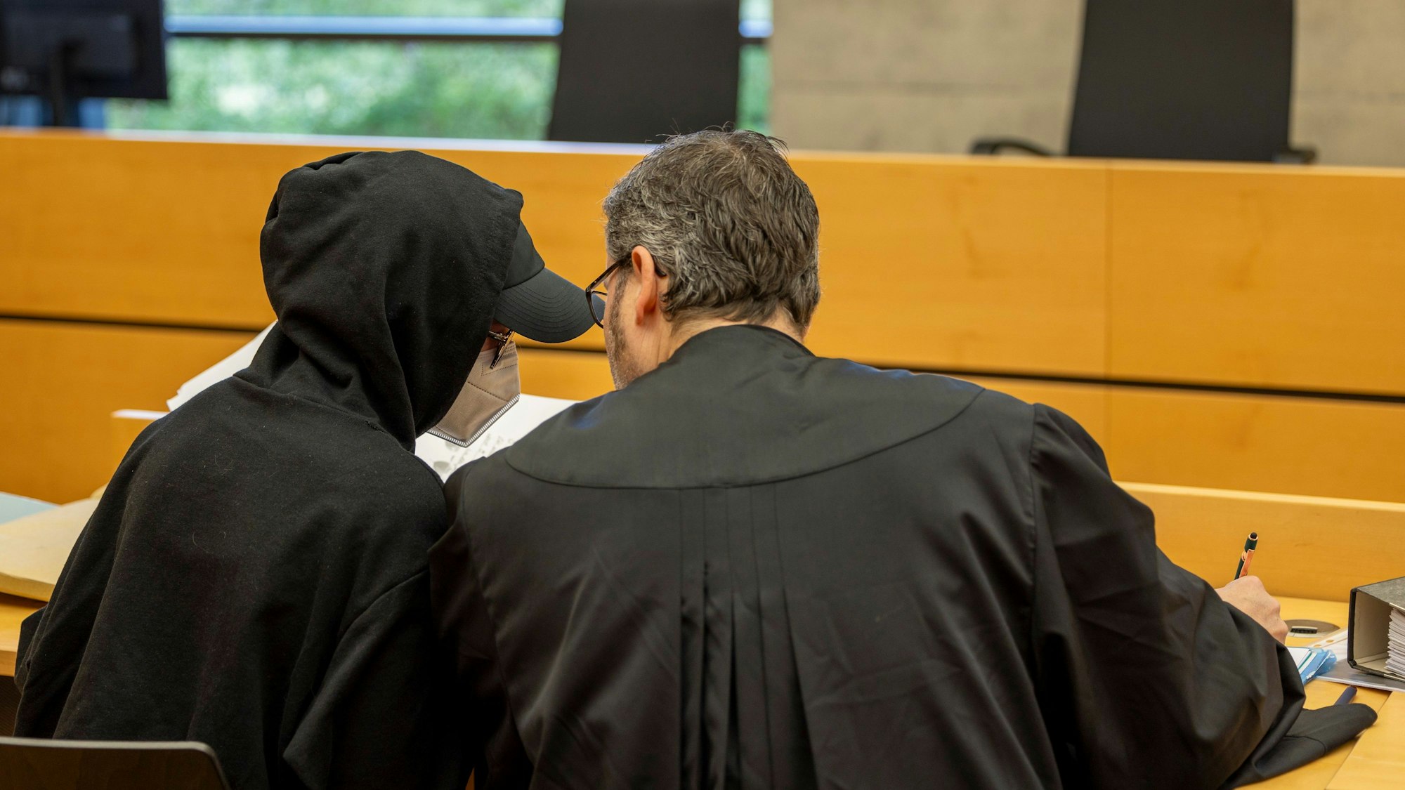 dpatopbilder - 08.04.2024, Bayern, Würzburg: Eine der beiden Angeklagten (31, l) unterhält sich mit ihrem Rechtsanwalt Hans-Jochen Schrepfer im Sitzungssaal im Landgericht.