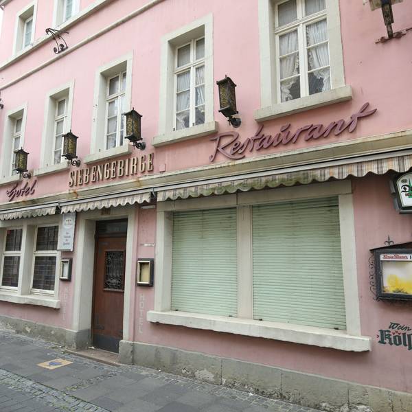 Ein ehemaliges Restaurant mit geschlossenen Rollläden an zwei Fenstern in der Fußgängerzone von Königswinter
