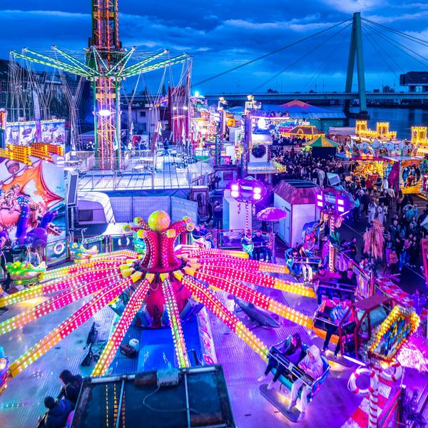 Die Deutzer Kirmes leuchtet in der Abenddämmerung: Im Vorfeld hatte es auch Streitigkeiten um die Stromversorgung gegeben.