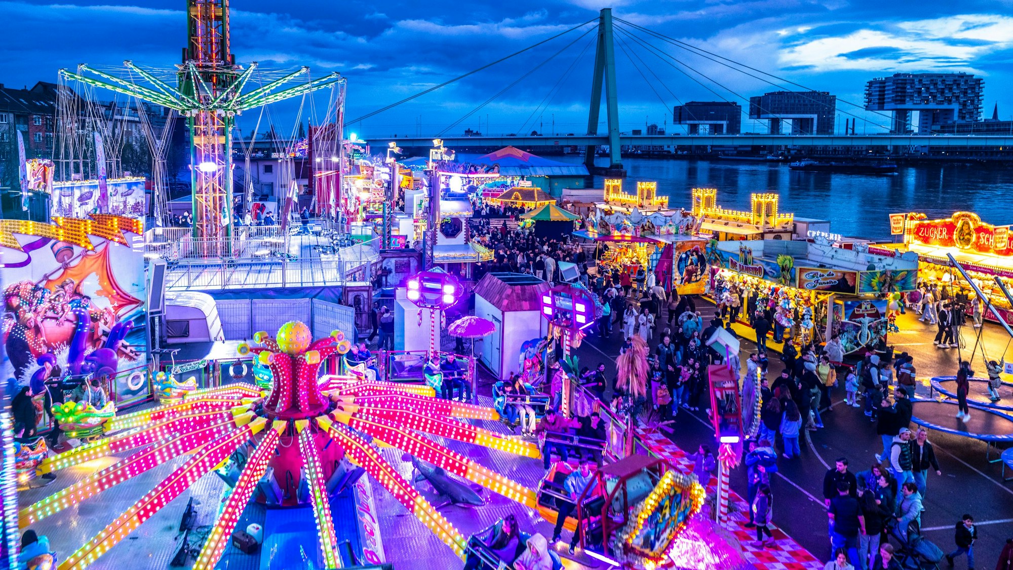 Die Deutzer Kirmes leuchtet in der Abenddämmerung: Im Vorfeld hatte es auch Streitigkeiten um die Stromversorgung gegeben.