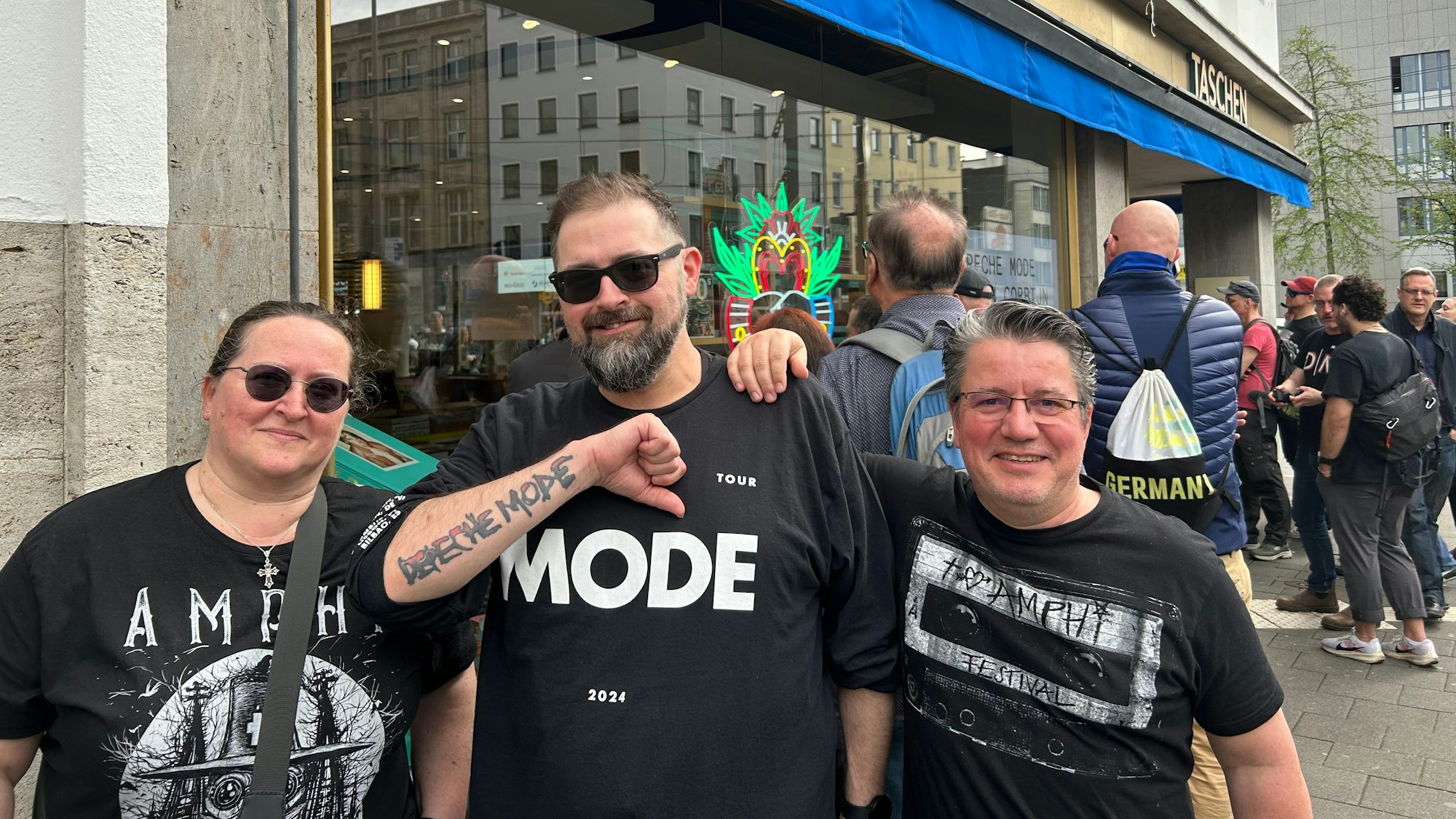 Eine Frau und zwei Männer stehen vor der Buchhandlung des Taschen-Verlags.