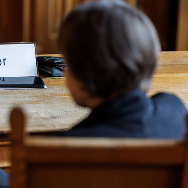 ARCHIV - 03.07.2023, Bayern, Bamberg: Eine Frau, die den Impfstoffhersteller Astrazeneca auf Schadenersatz verklagt, sitzt vor Beginn einer Berufungsverhandlung im Oberlandesgericht (OLG) Bamberg.