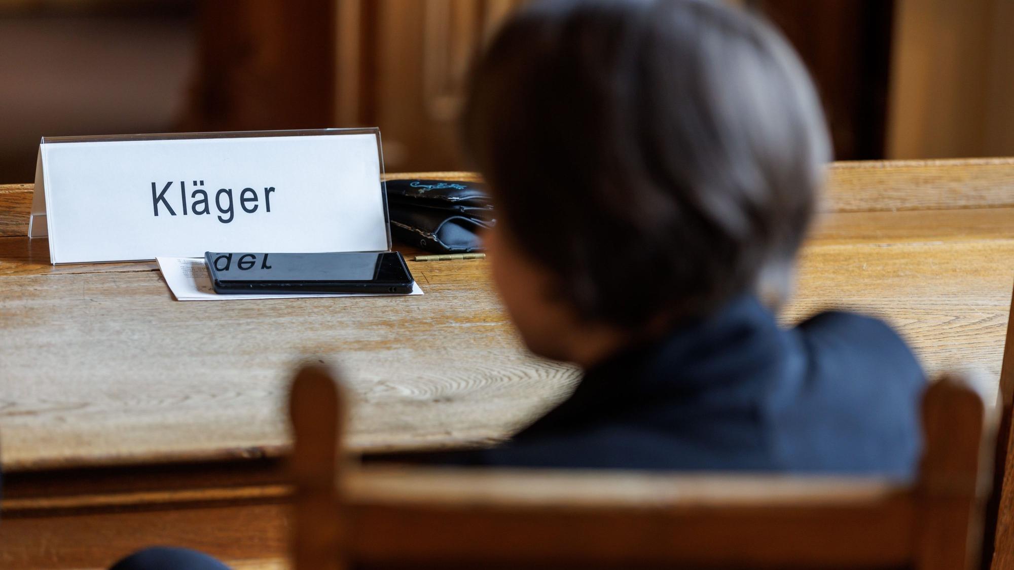 ARCHIV - 03.07.2023, Bayern, Bamberg: Eine Frau, die den Impfstoffhersteller Astrazeneca auf Schadenersatz verklagt, sitzt vor Beginn einer Berufungsverhandlung im Oberlandesgericht (OLG) Bamberg.